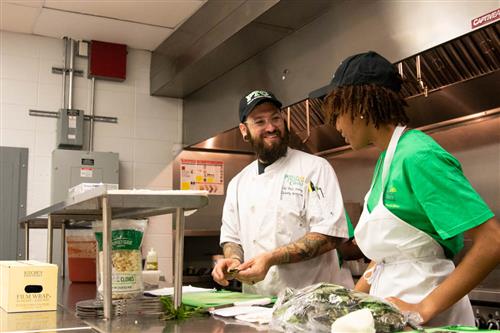 Chef Felix working with a student at culinary camp